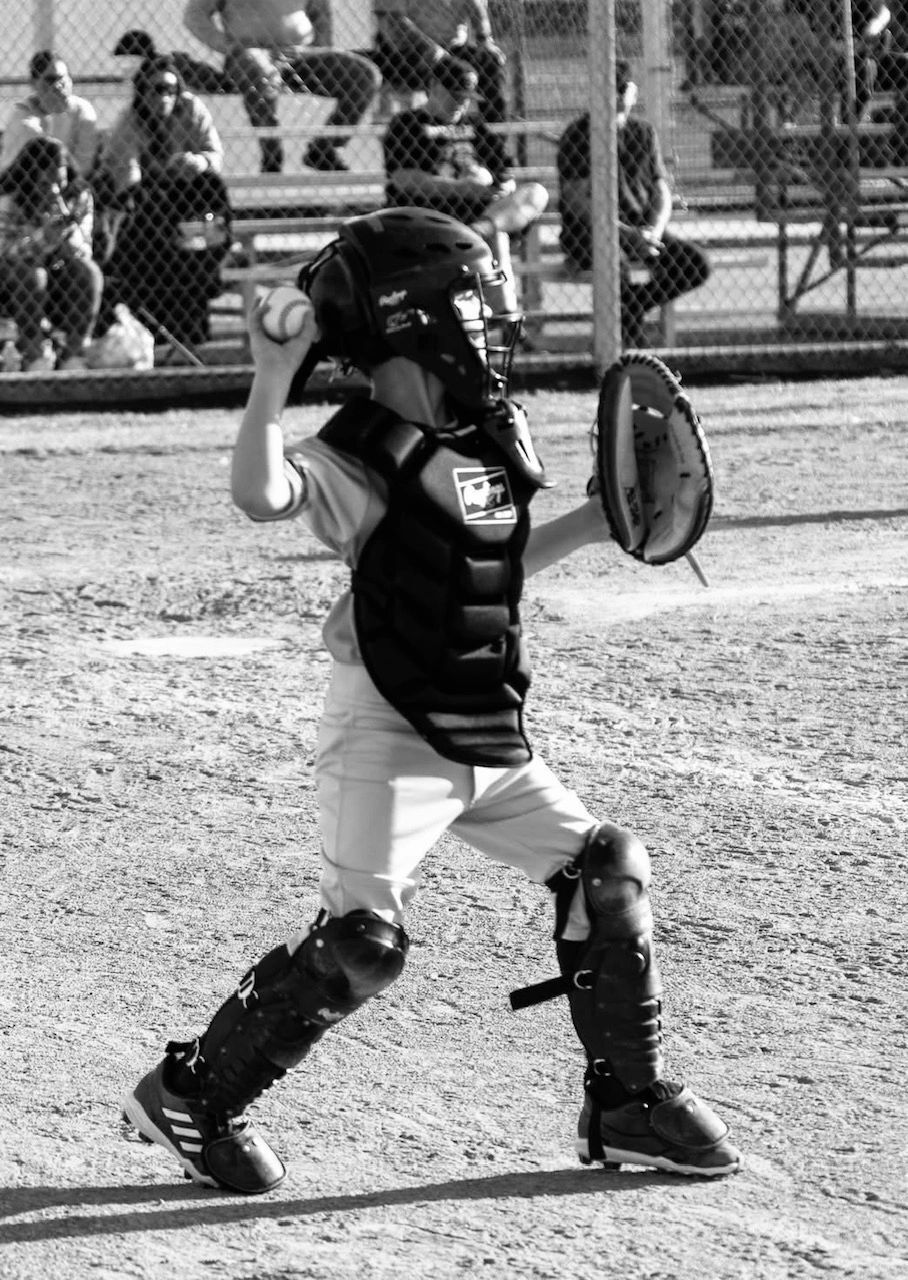 Young catcher in full gear making a throw