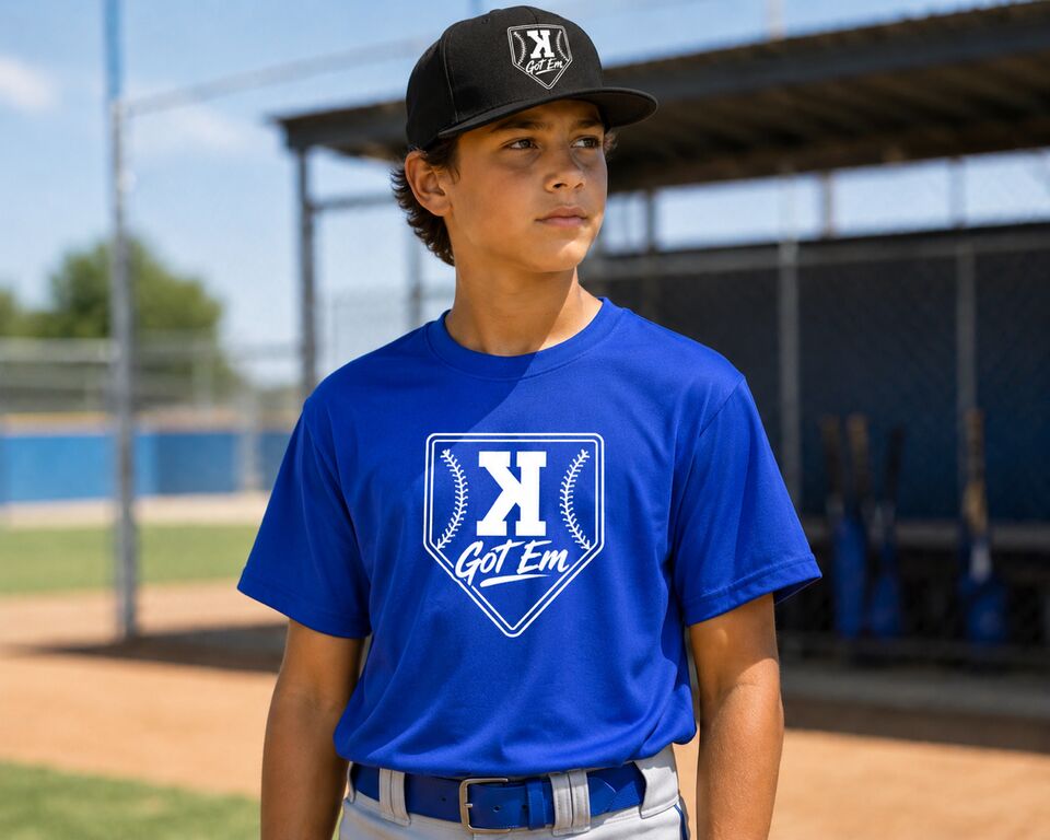 Player in the royal blue Got 'Em tee and black hat by the dugout